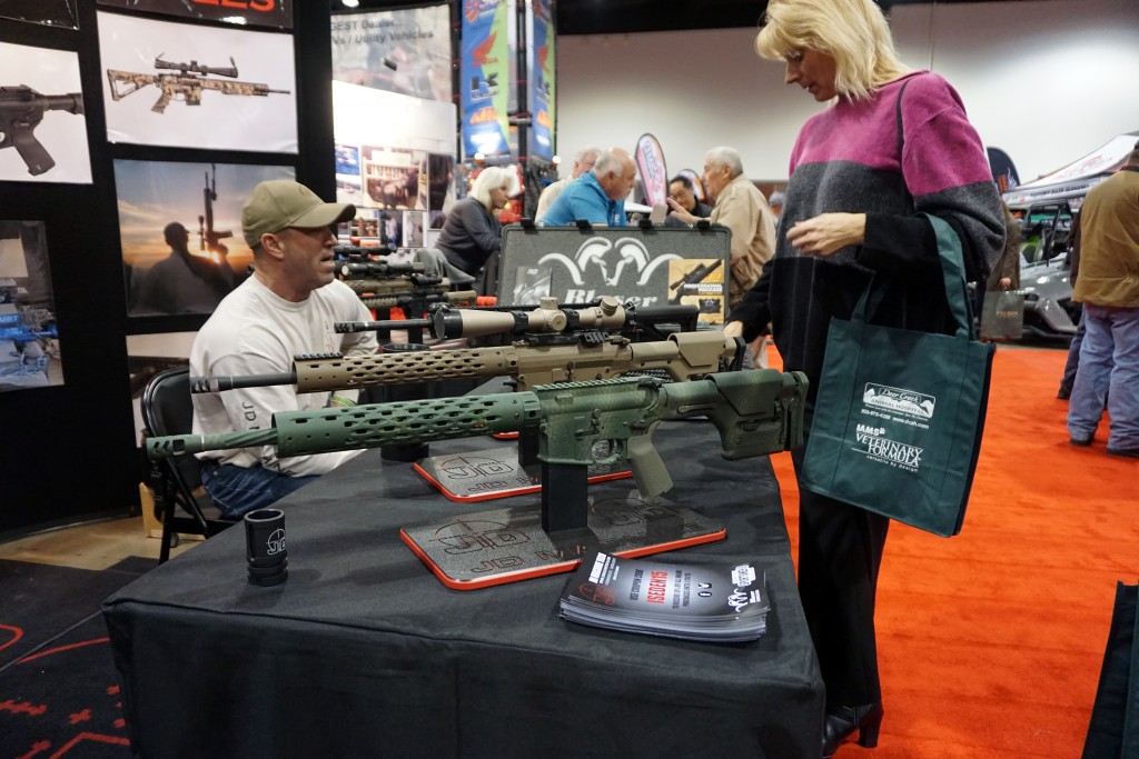 A woman looks at guns built by JD Machinetech at the expo. Photos by George Demopoulos. 