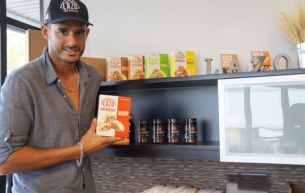 Francois Saber displays a box of empanadas in the office. (Amy DiPierro)