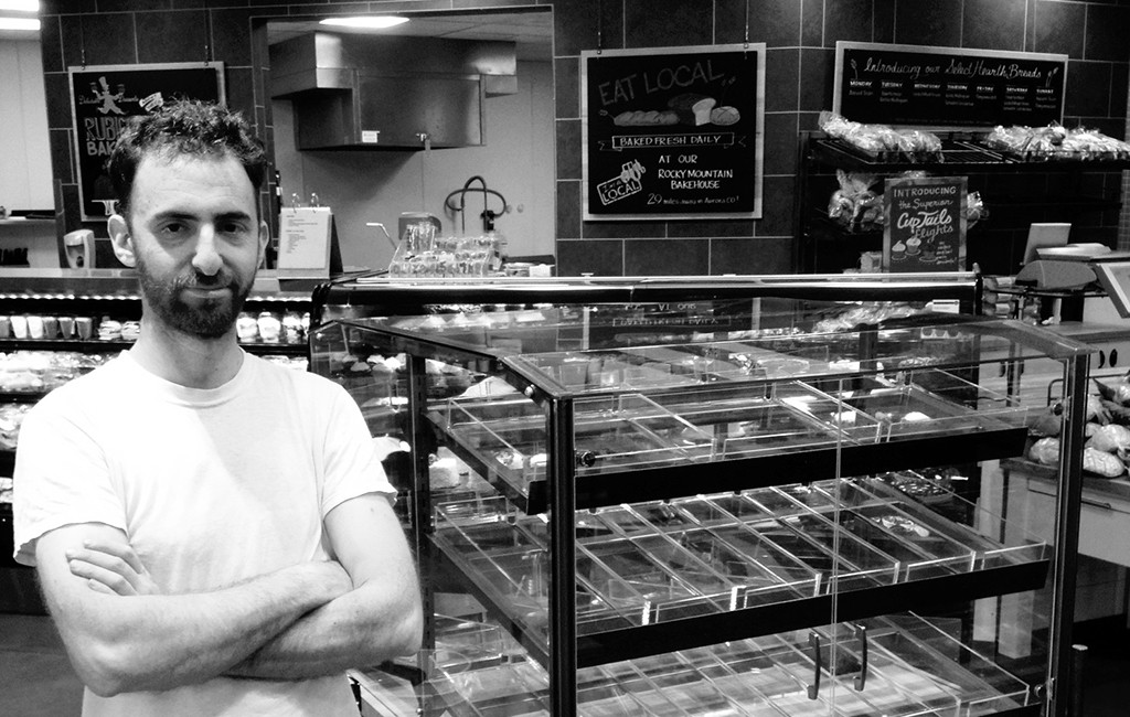 Aaron Holtzer stands next to a Holtz display case at a grocery store. (Courtesy Holtz)