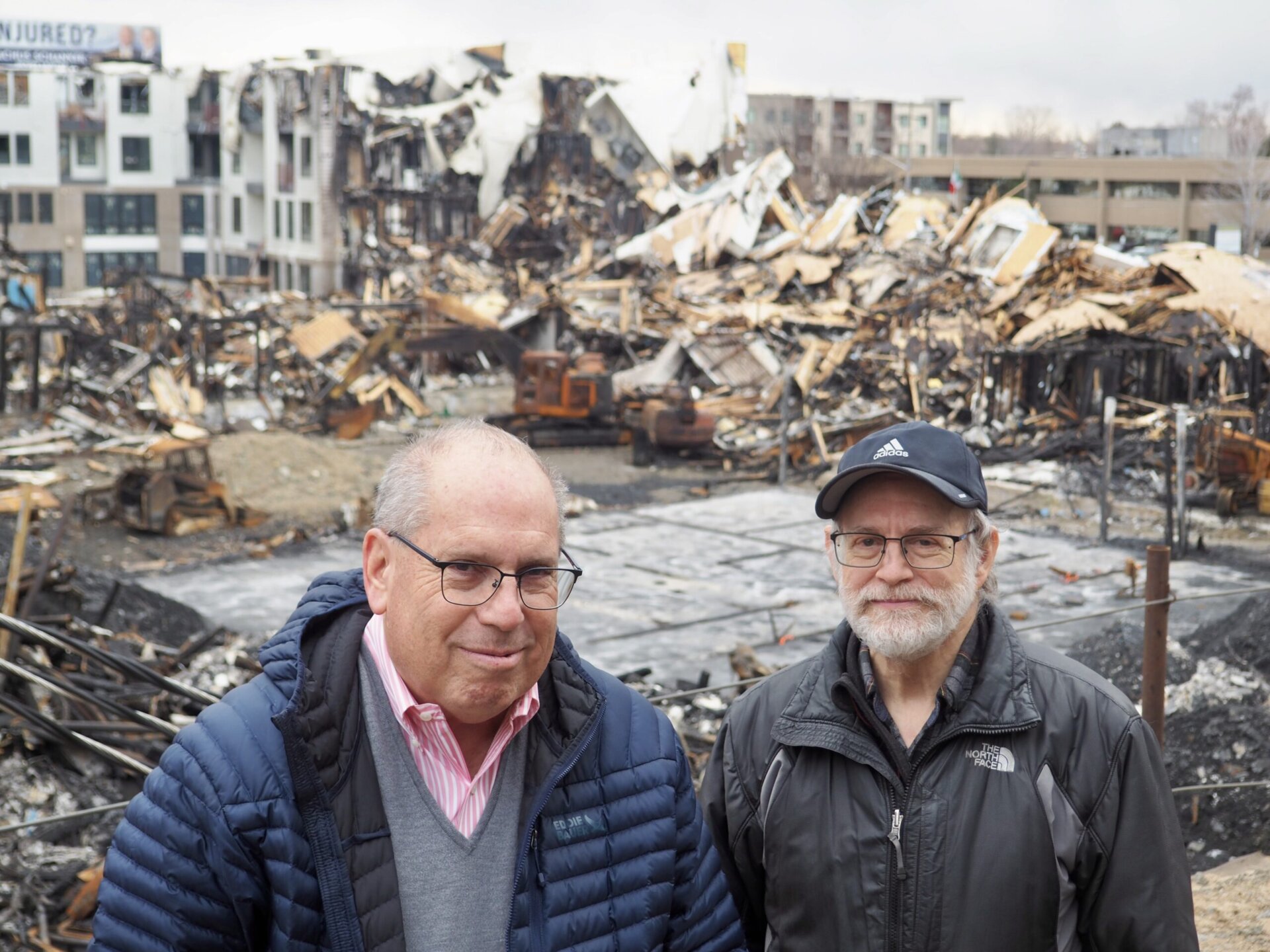 two people standing in front of fire damage