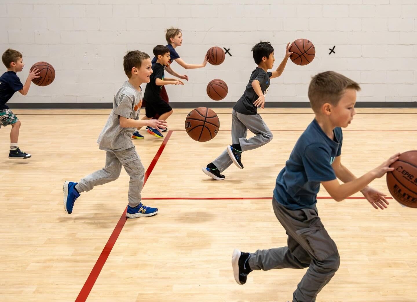 Children play basketball at achieve sports