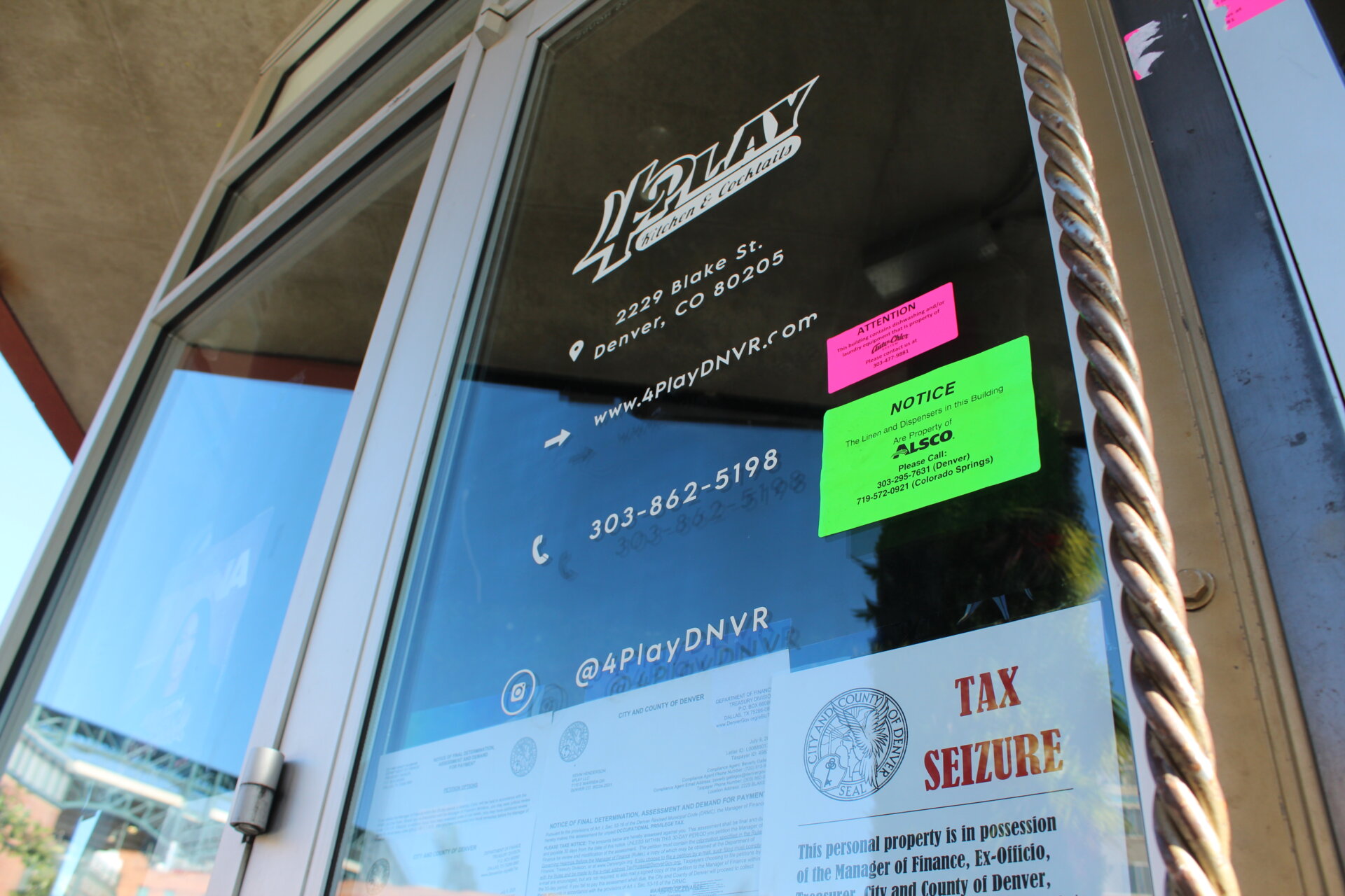 The front door of 4Play, which has a tax seizure notice.