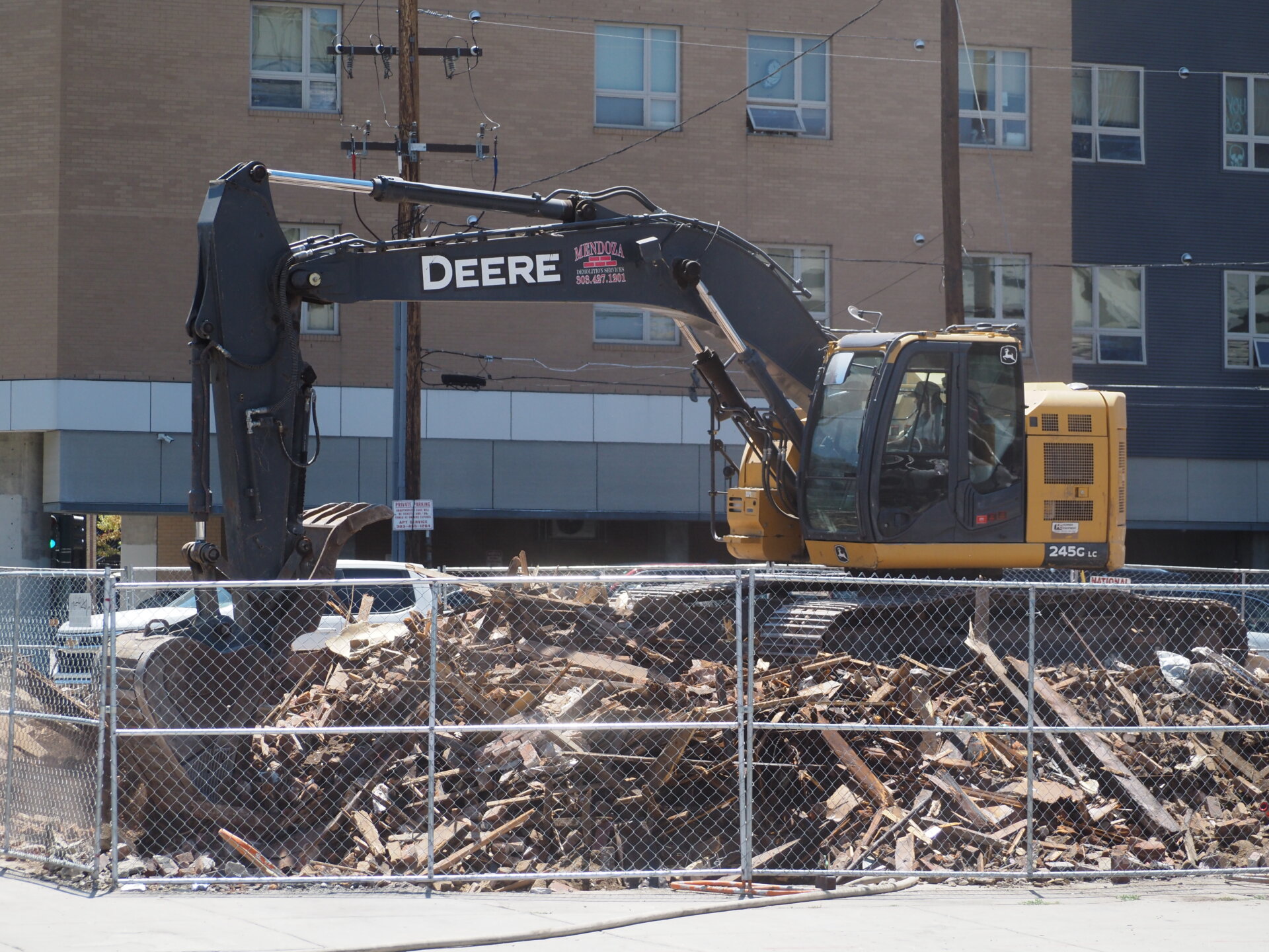 Excavator works after demolition of Denver dive bar