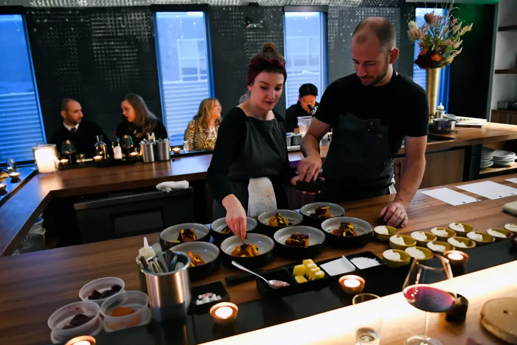 Chefs Duncan Holmes and Carrie Cross preparing a dish during service at Beckon.